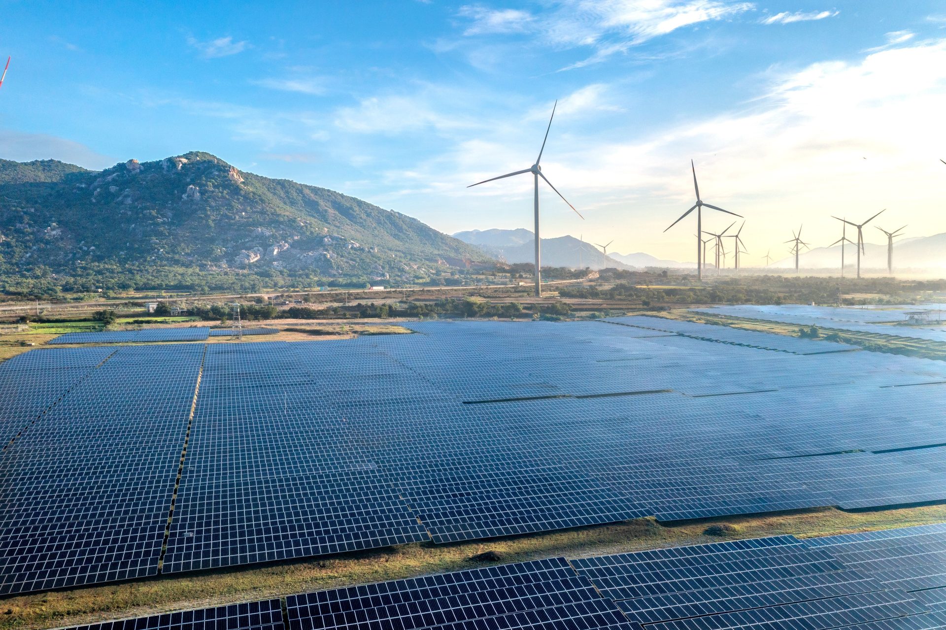 Luftaufnahme eines Solar- und Windparks vor der malerischen Landschaft Vietnams.